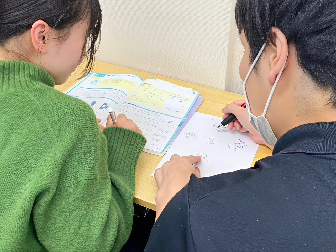 個個塾で、隣に座って教材を一緒に確認する様子