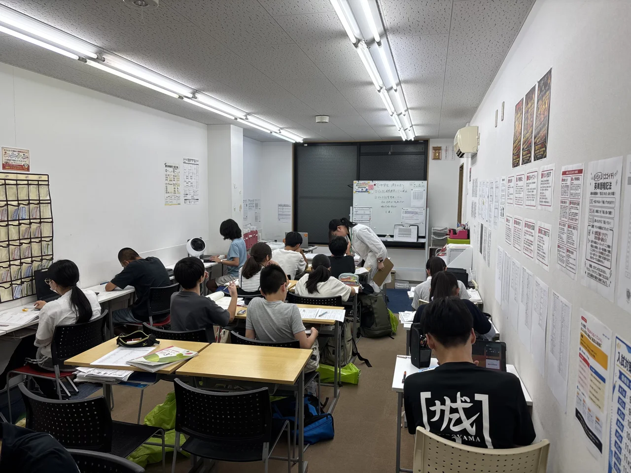 個個塾の教室で教材に取り組む生徒と先生