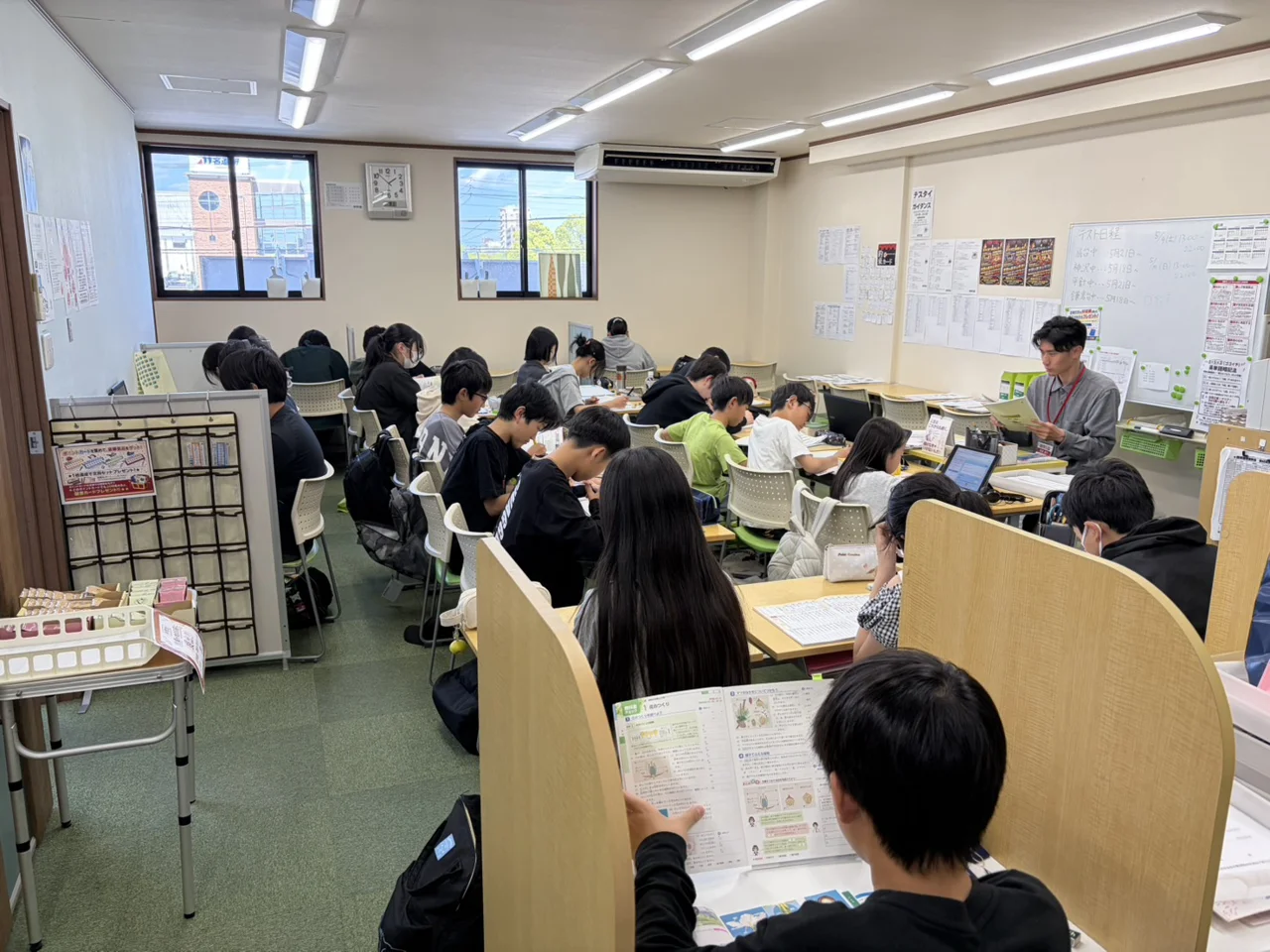 個個塾の教室で生徒たちが机に向かって教材に取り組む様子