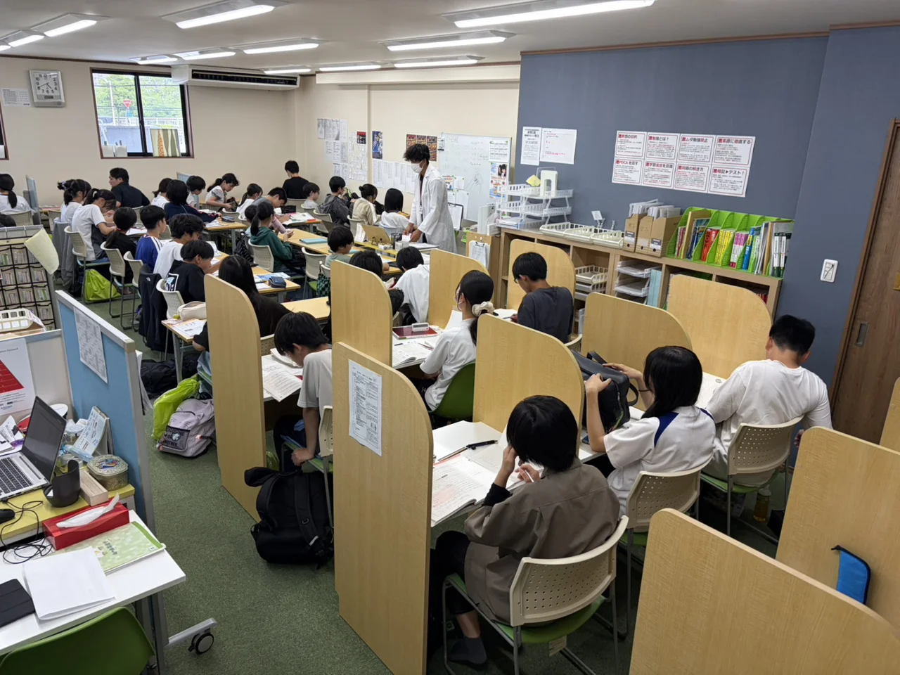 個個塾の仕切りのある机で生徒たちが学習する教室内の様子