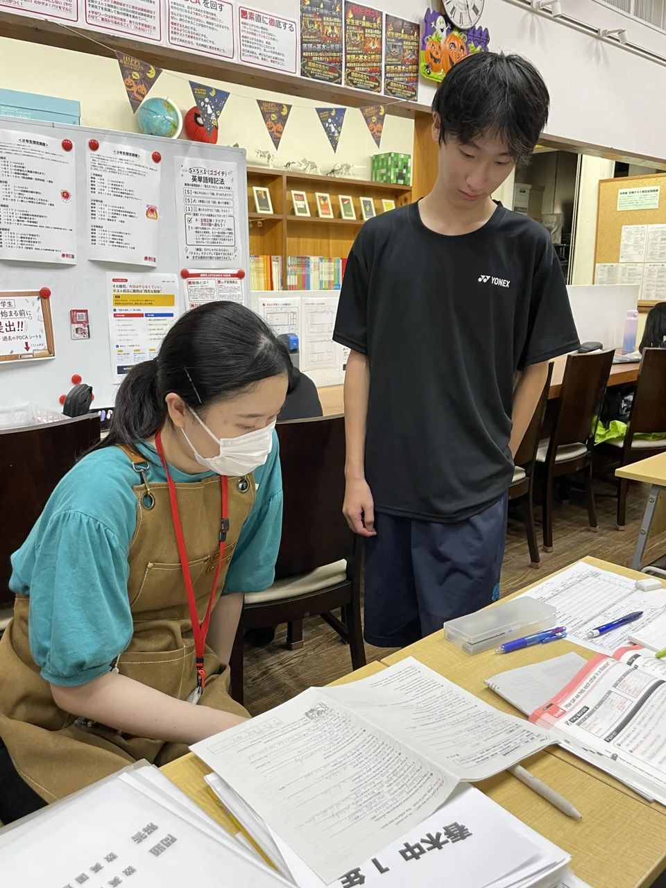 とうごう兵庫教室で教材を確認しながらやり取りする先生と生徒