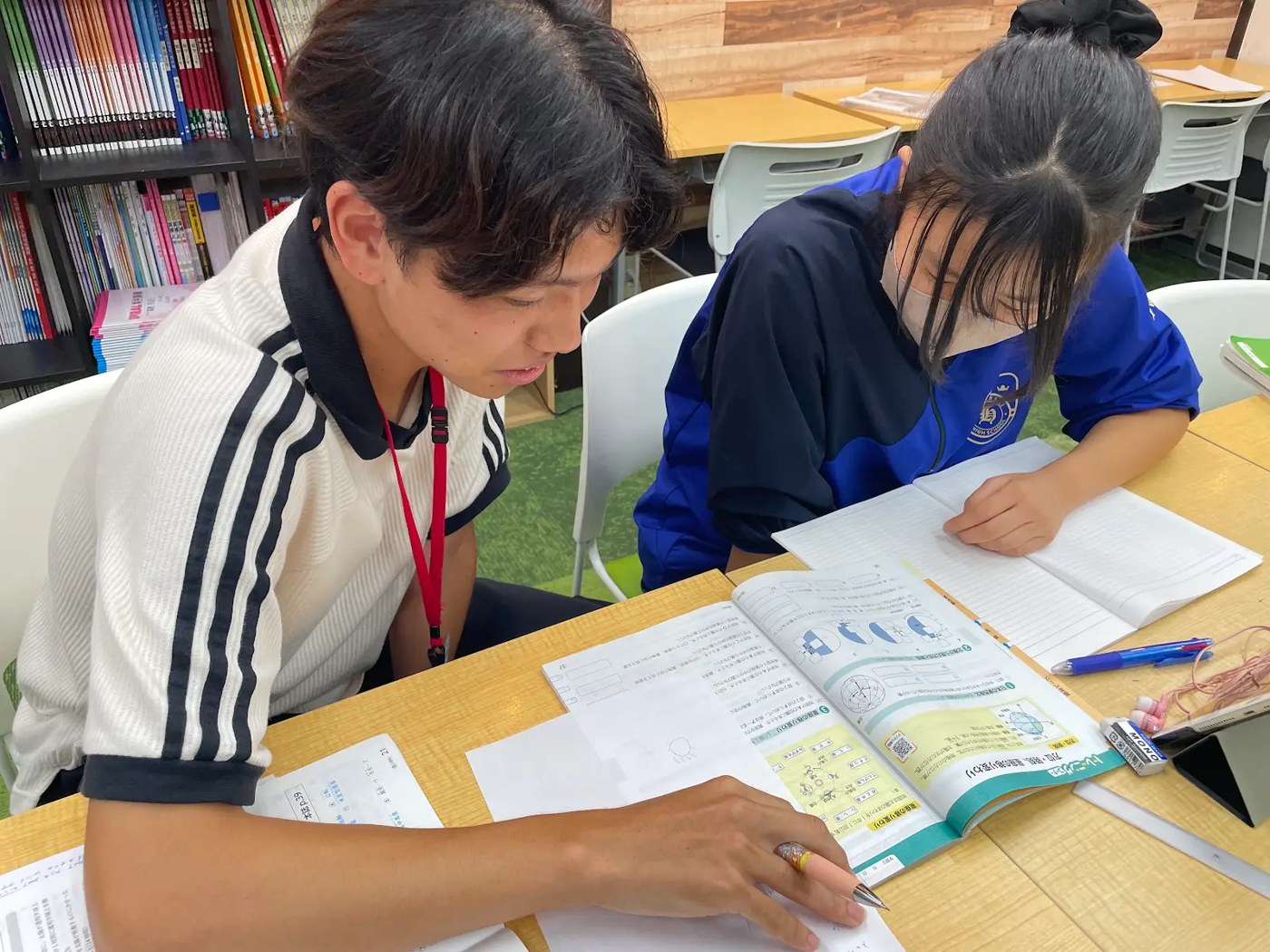 にっしん赤池教室で講師と教材を確認する生徒